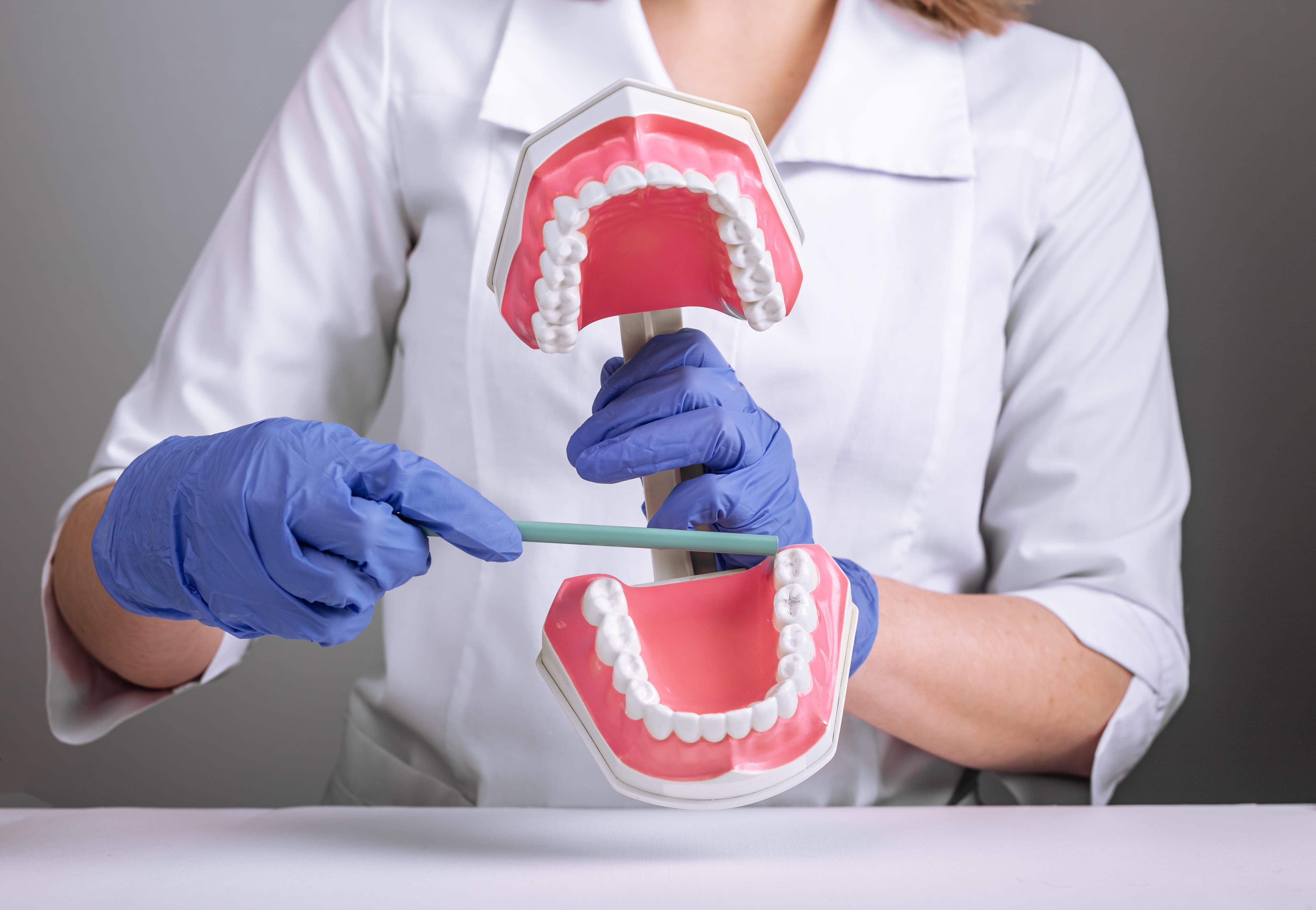 ทันตแพทย์กำลังอธิบายคนไข้ว่าฟันคุดคืออะไร และก่อนจัดฟันต้องถอนฟันคุดหรือไม่