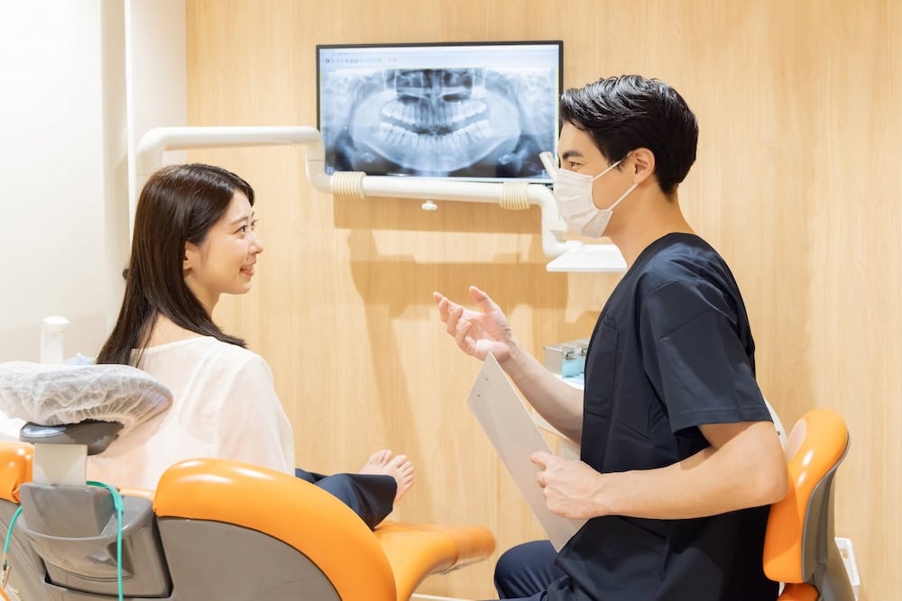 ทันตแพทย์กำลังอธิบายให้คนไข้ฟังเกี่ยวกับอาการปวดฟันเวลาเคี้ยวอาหาร